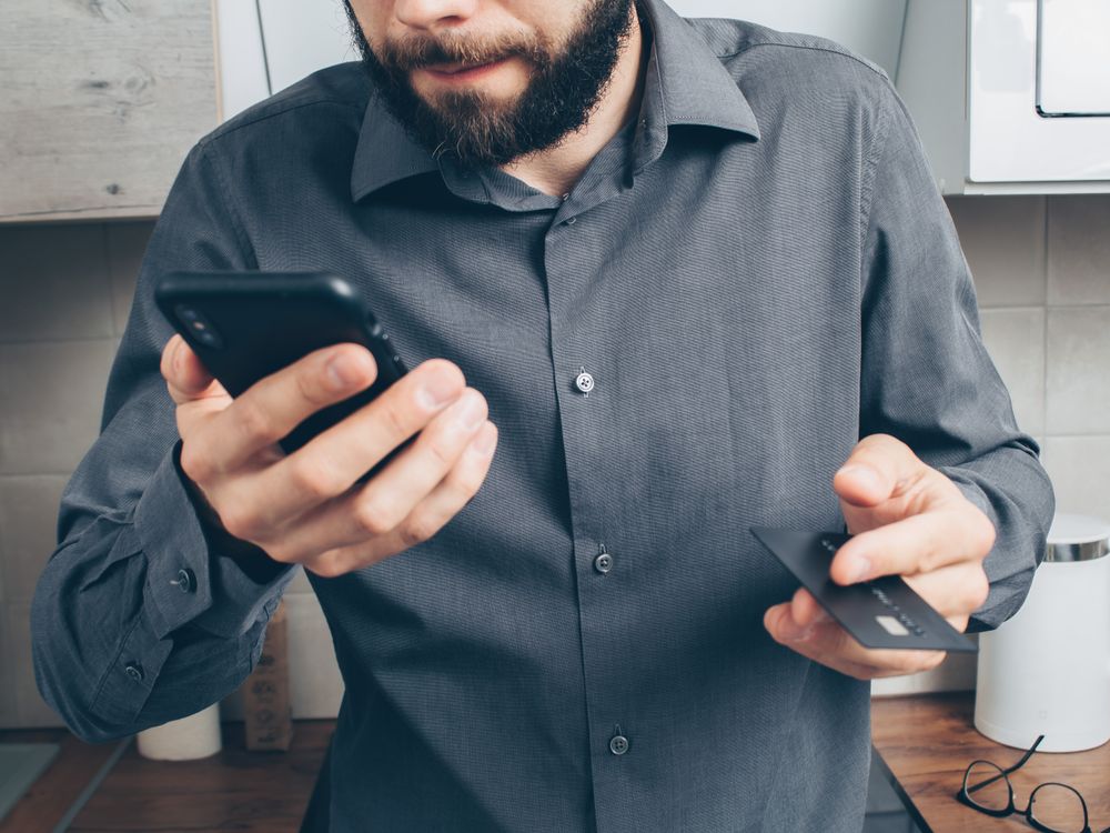 Man using a smartphone for online payment with a credit card