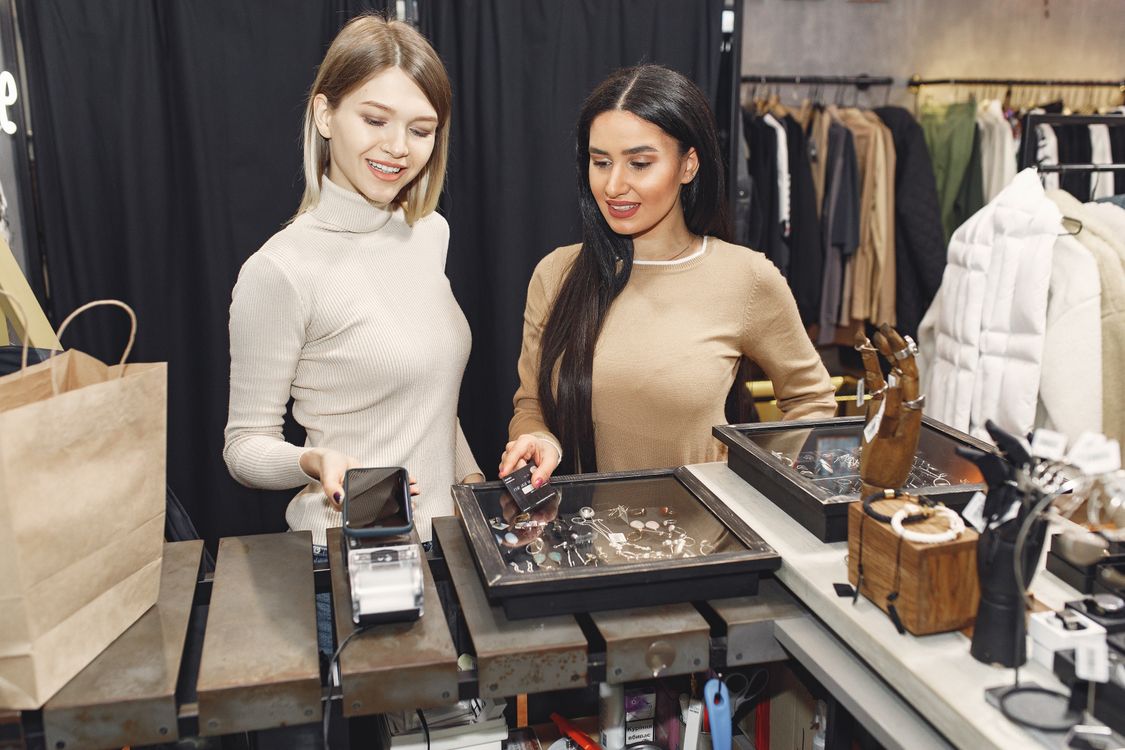 Two women making a contactless payment with a smartphone