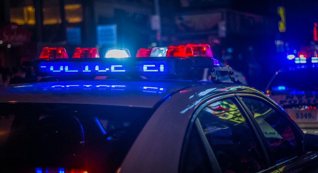A police car with flashing red and blue emergency lights at night