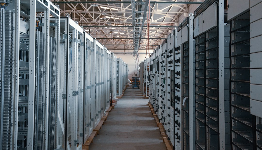 A long aisle between rows of server racks in a data center