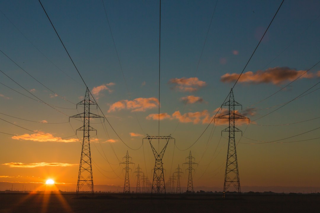 Electricity transmission towers silhouetted at sunset