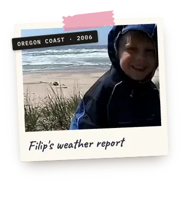 Polaroid: a grinning boy in a rain hood on a windy beach. Label: Oregon coast, 2006