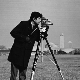 An image from the 1960s or 70s of a man standing behind a camera on a tripod on a lawn.