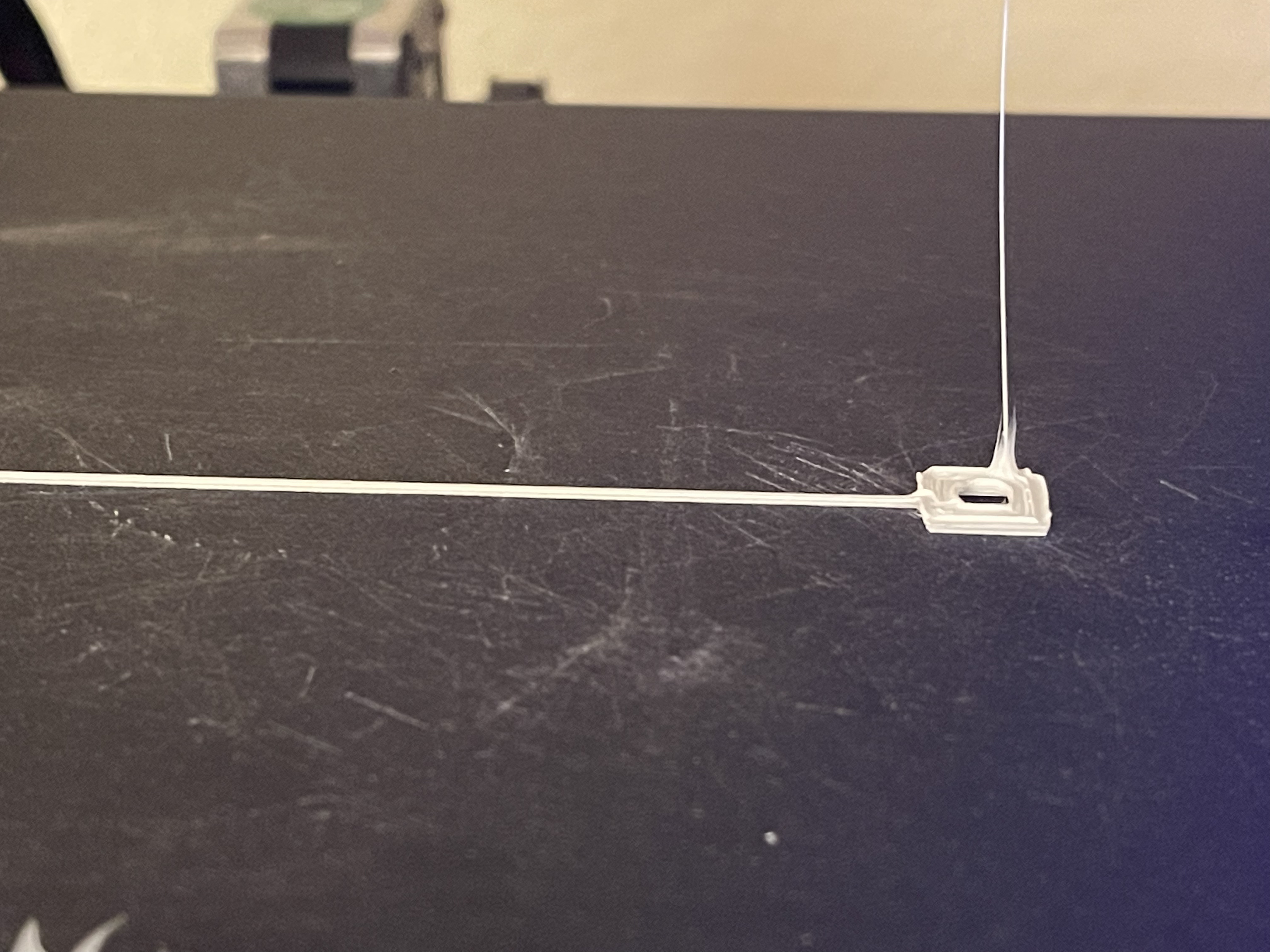 An image of a 3D printing bed where plastic has been over-extruded and is sticking to the print head.