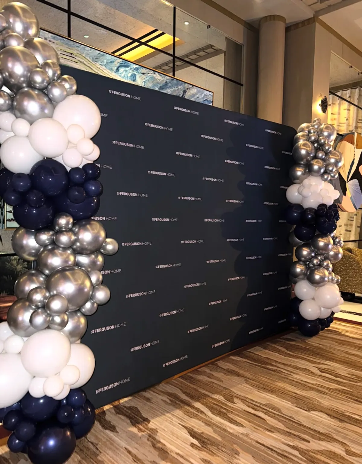 Elegant branded backdrop with silver and white balloons