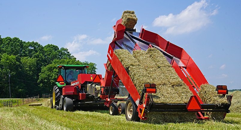 A baler making bales of hay on a farm
