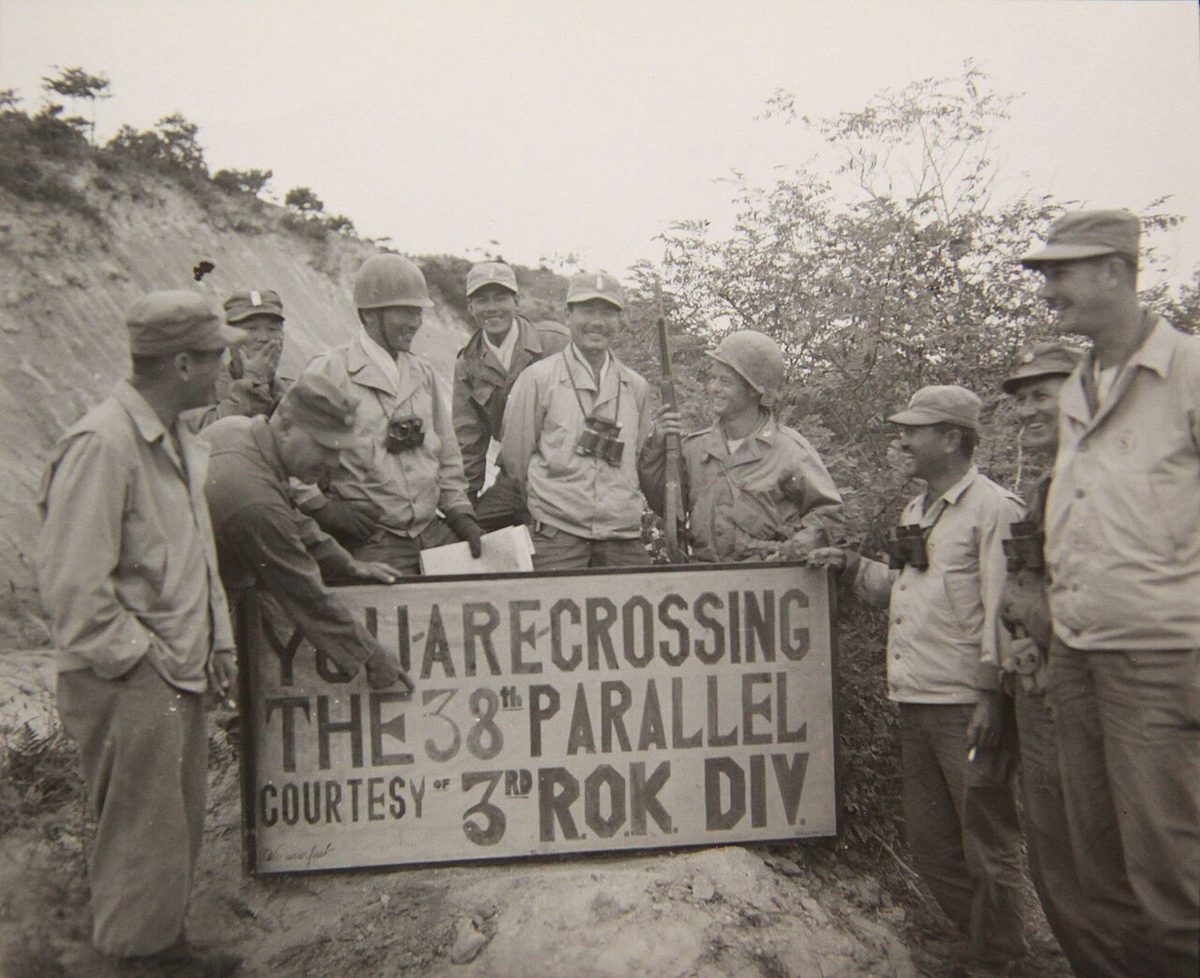 Officers post a sign marking the 38th parallel crossing as UN forces advance north, autumn 1950