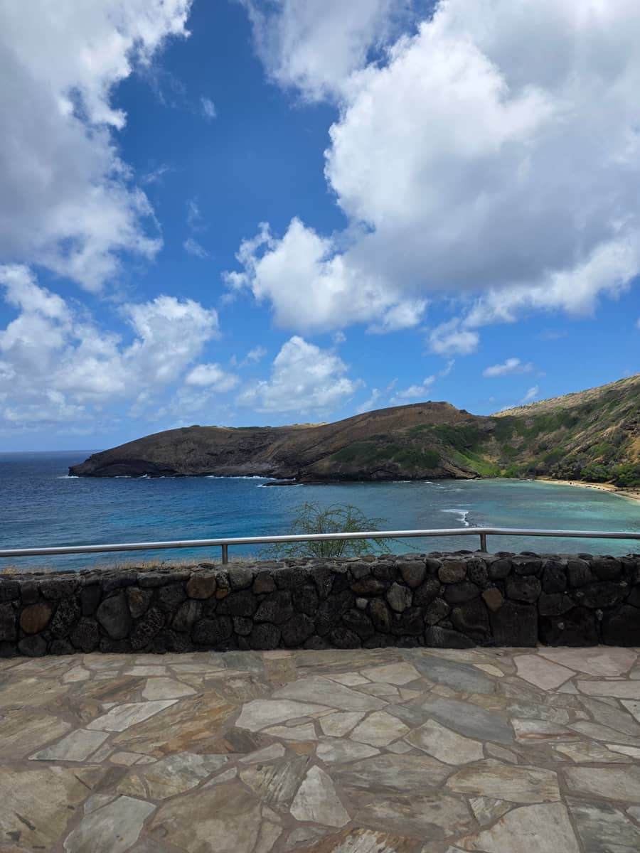 동부 해안 드라이브 전망 포인트 — 돌담 너머 에메랄드빛 바다와 푸른 산 능선