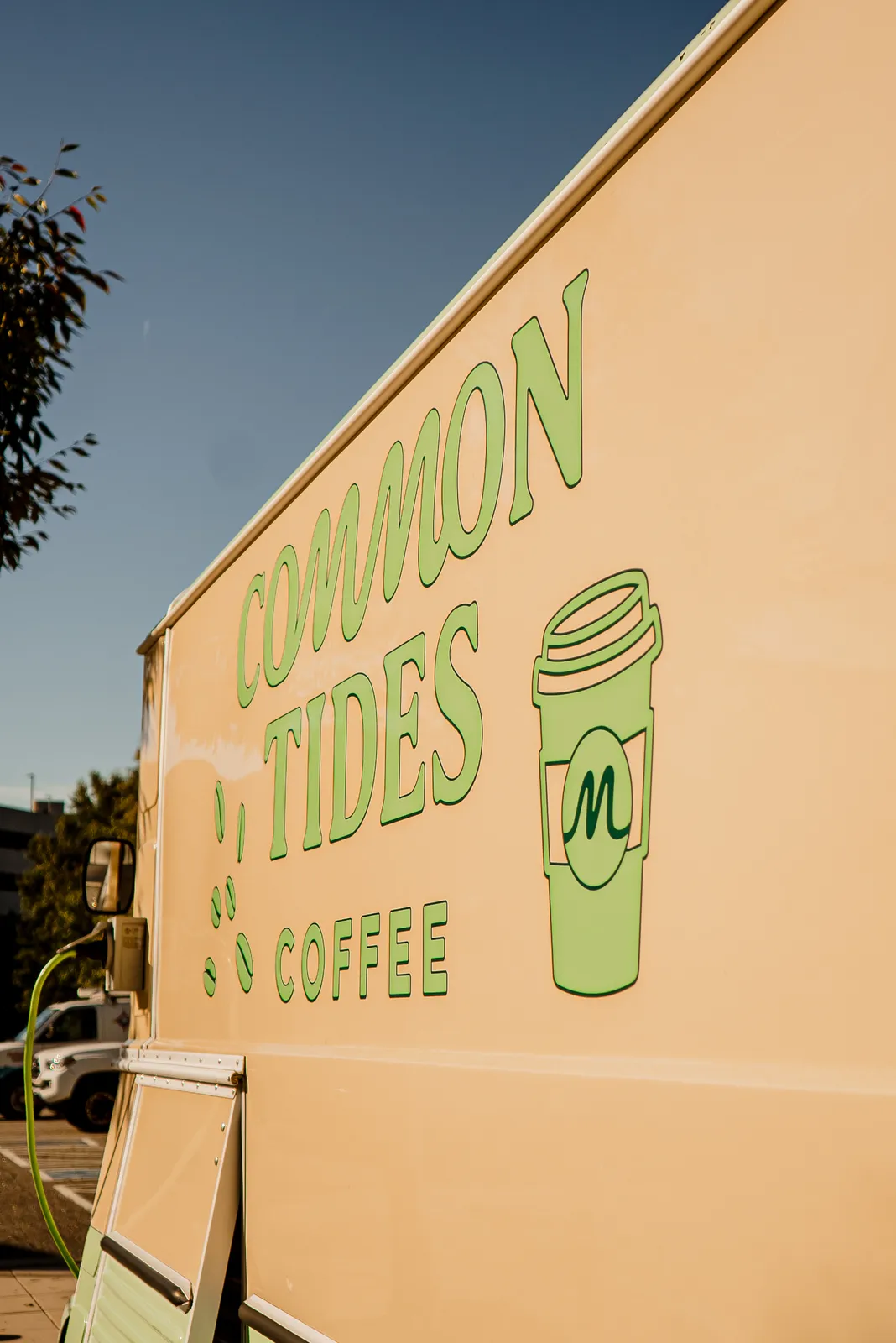 Common Tides Coffee lettering painted on the side of the trailer in the afternoon sun