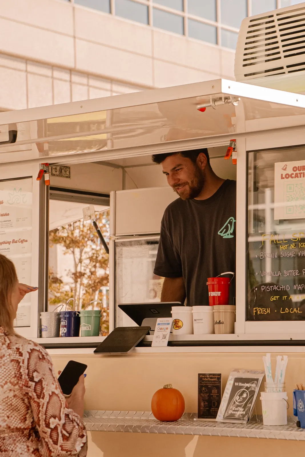 Zack Bennett handing a drink to a customer at the Common Tides trailer window