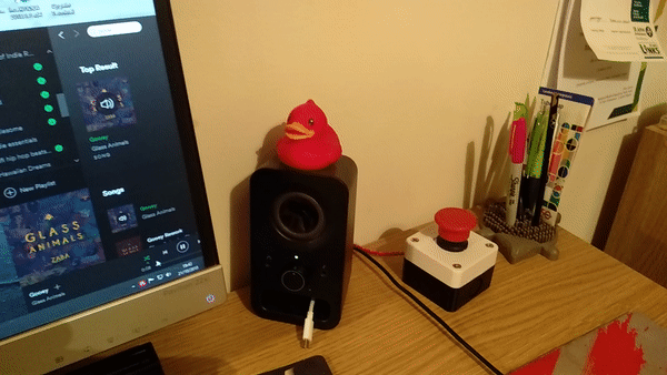 GIF of button being pressed with Spotify open, showing a song being paused