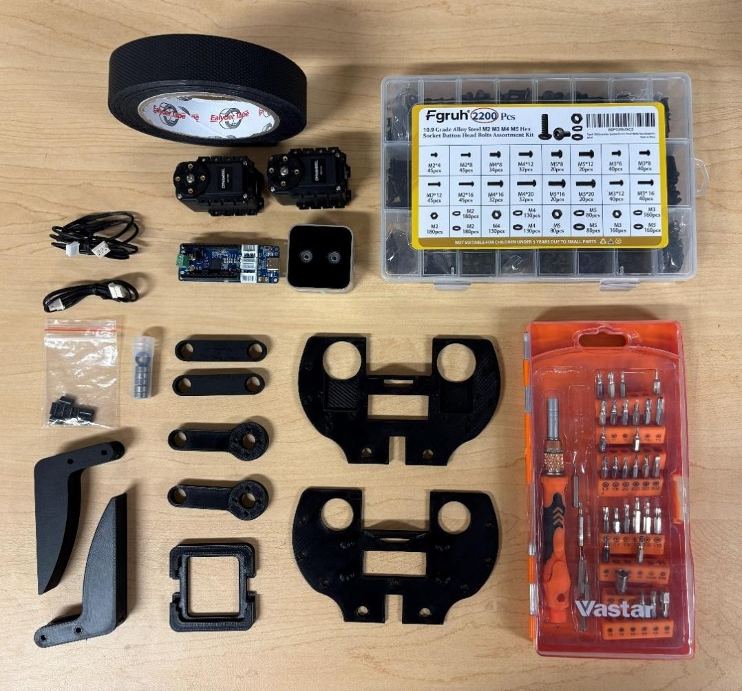 Every part of the gripper laid out on a bench