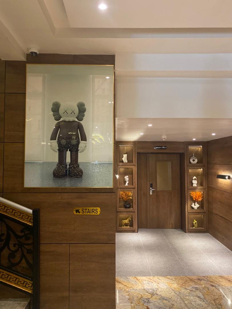 Frank N Hotels Royal cultural corridor with framed art, wood finishes, and curated heritage details.