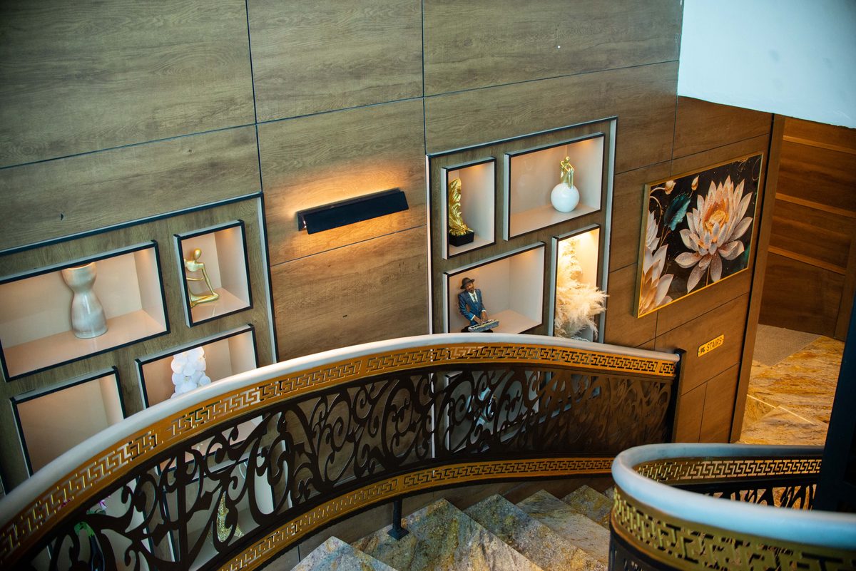 The Grand Staircase at Frank N Hotels Royal — ornate gold wrought-iron railings and sculptural art niches
