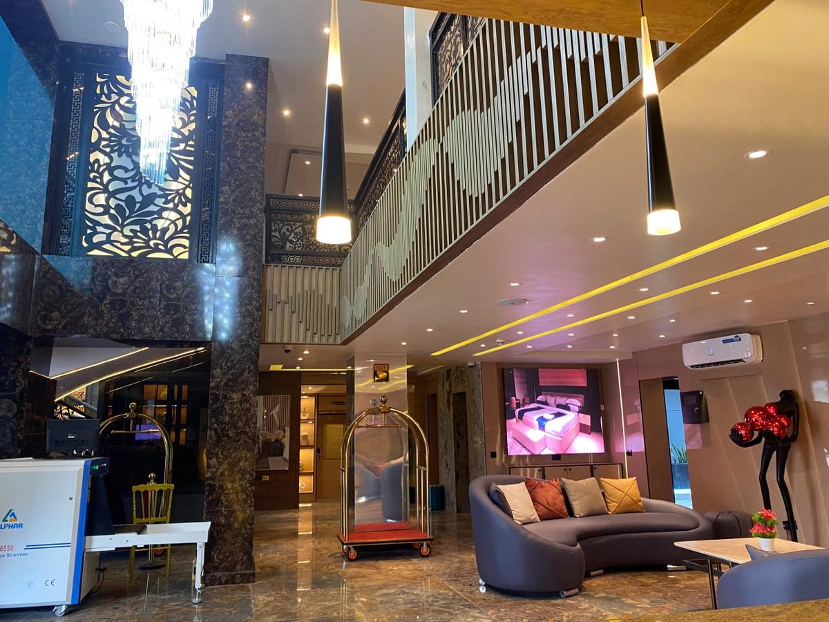 The Royal Lobby at Frank N Hotels Royal — double-height atrium, crystal chandelier, marble columns