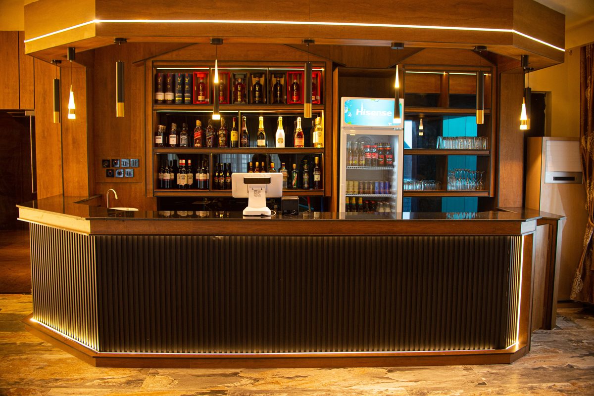 The VIP Bar at Frank N Hotels Royal — curated spirits, warm lighting, and mahogany cabinetry