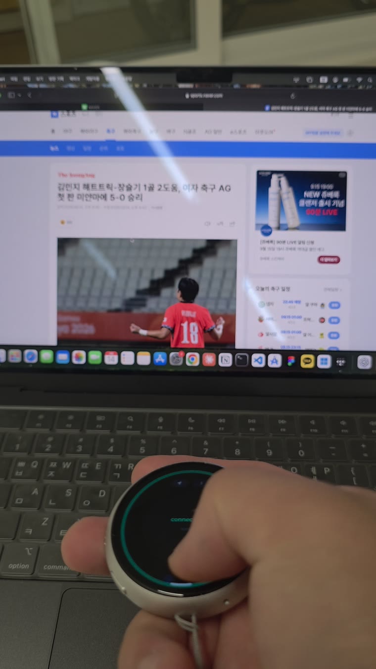 the badge in hand on a laptop keyboard, driving the screen above it