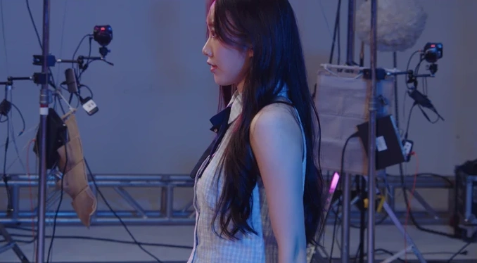 Scene 3: performer in a purple-lit studio, long-focus view