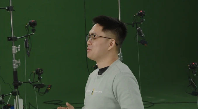 Scene 4: performer in a green studio, long-focus view