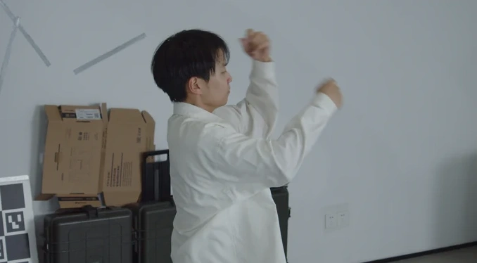 Scene 5: performer in a white studio, long-focus view