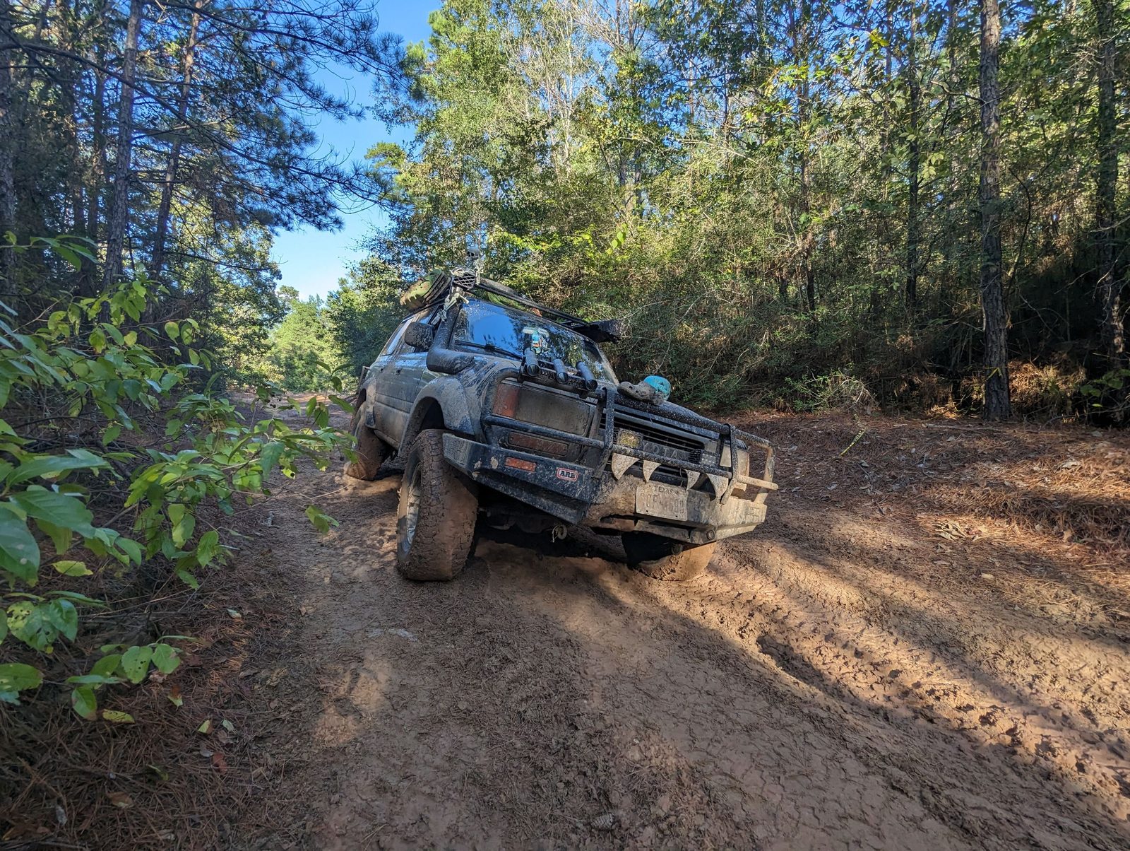 Toyota Land Cruiser crossing a muddy off-road trail with ARB front bumper