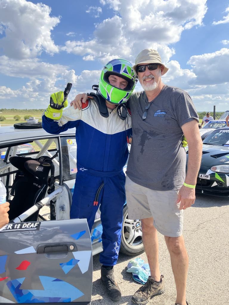 Ben embracing his father trackside with a 'DRIVER IS DEAF' door decal visible