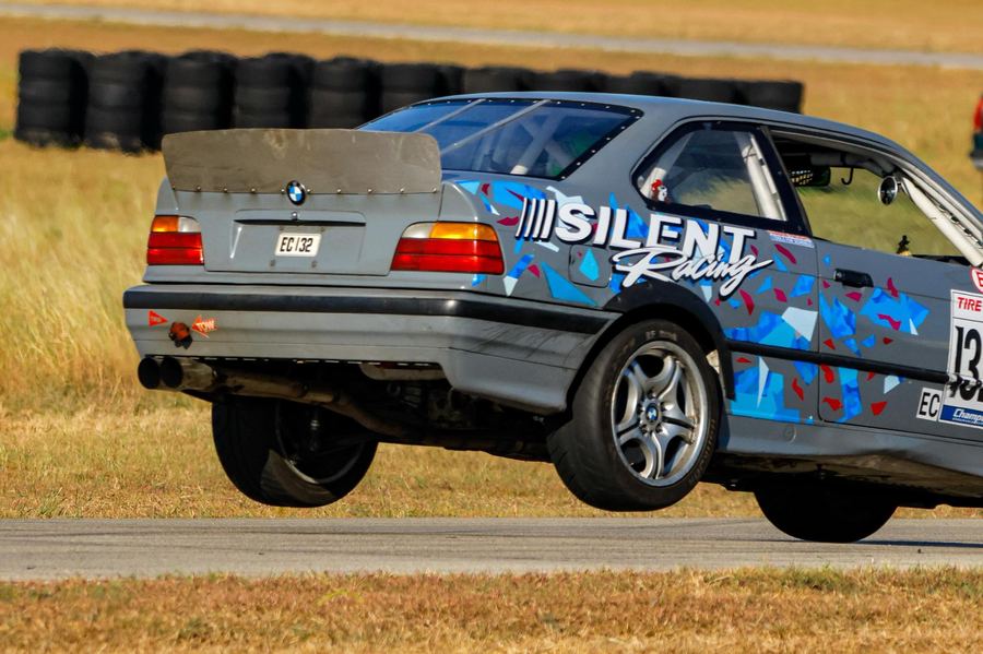 Silent Racing BMW E36 jumping curbing at Harris Hill Raceway