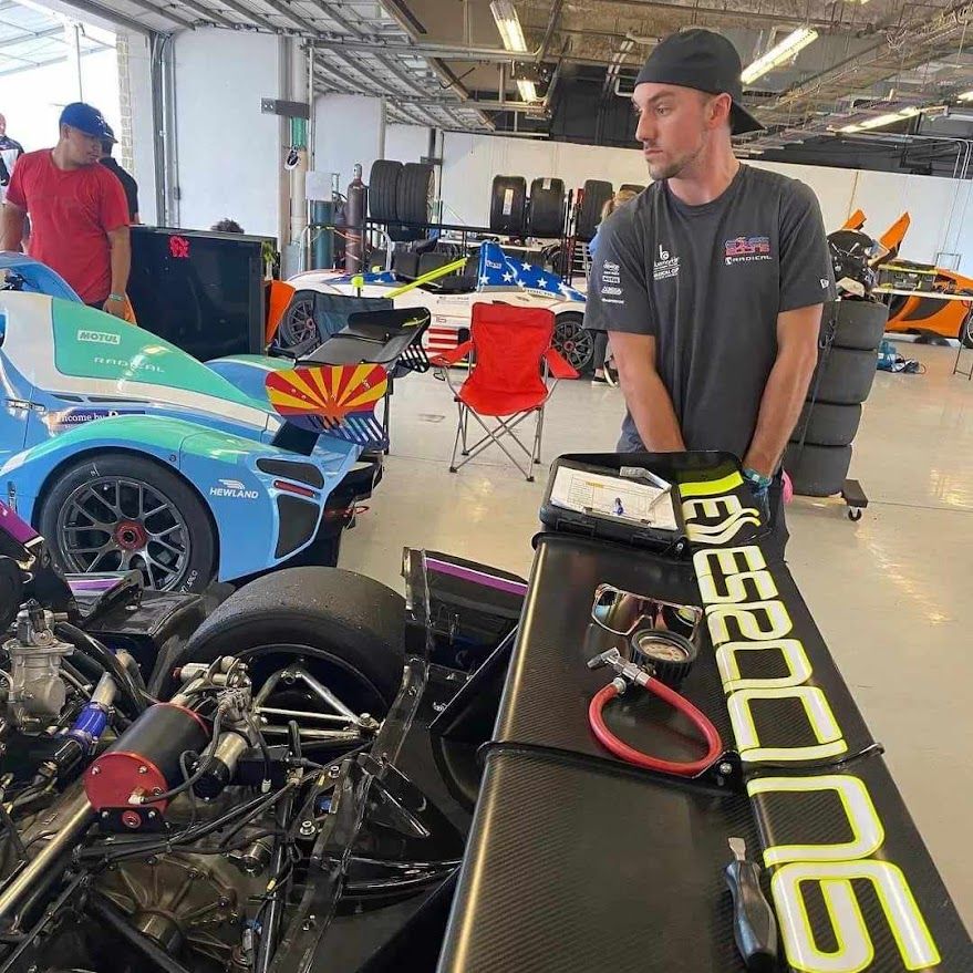 Ben working in the paddock alongside professional race cars