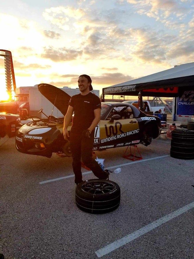 Ben posing with the Winding Road Racing Mazda MX-5 at sunset