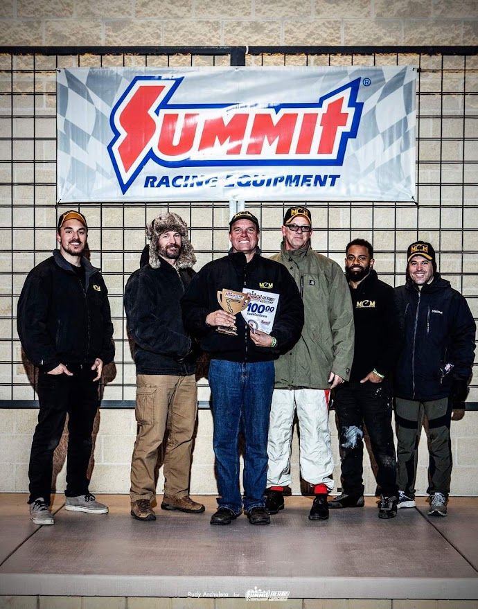 Matt Connolly Motorsports team with an award in front of a Summit Racing banner