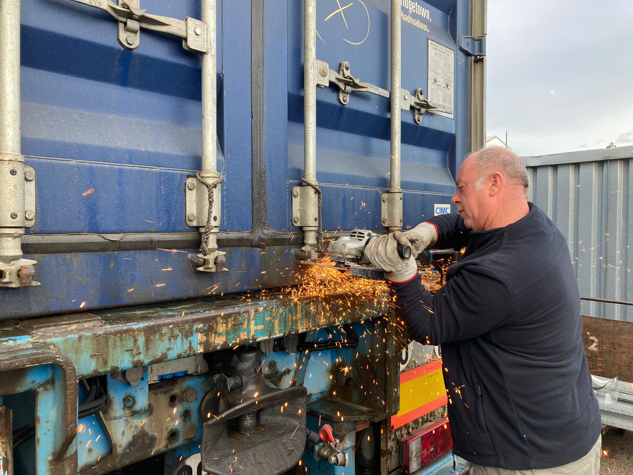 a person using a circular saw to remove the locks on a container