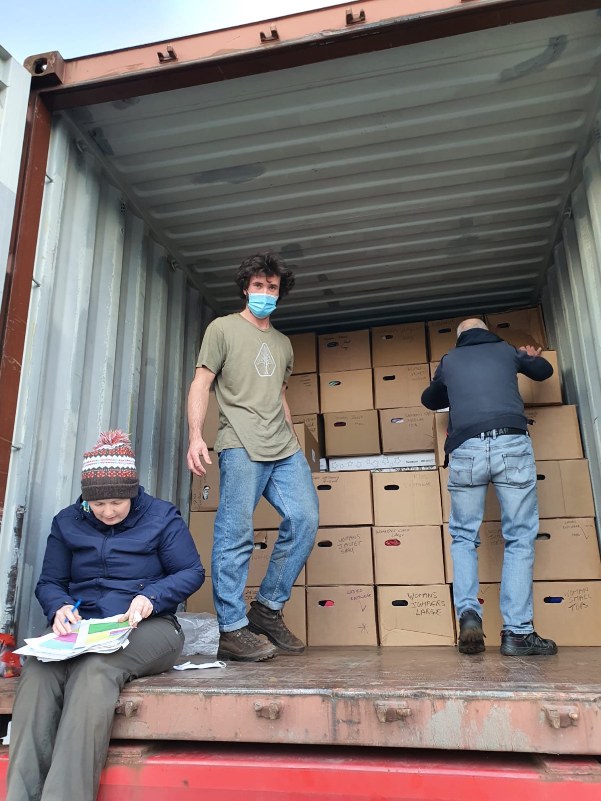 volunteers loading a truck of boxes of aid items