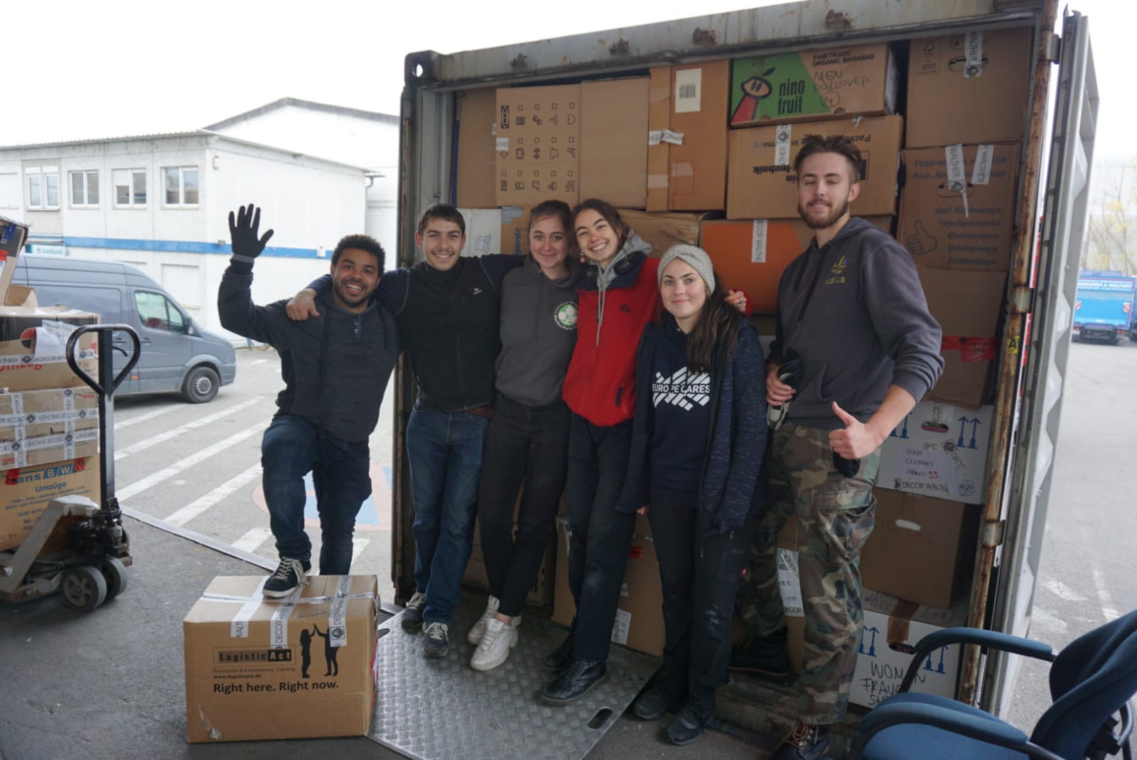 volunteers standing next to a truck they have filled to full capacity with boxes of donated items, posing for a photo