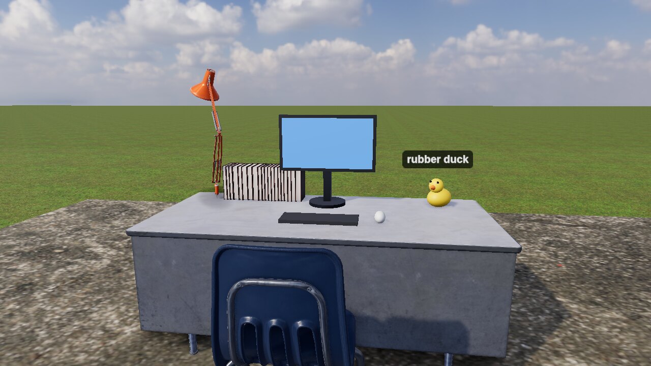 A desk with a monitor, a lamp, and a rubber duck made of spheres