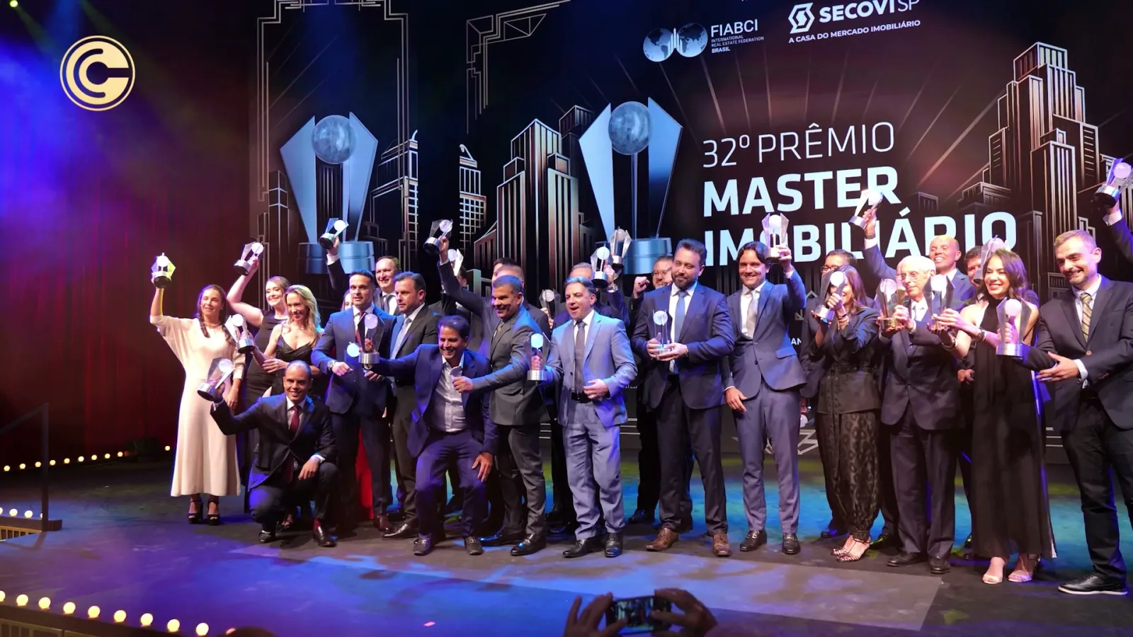 Todos os premiados da 32ª edição do Prêmio Master Imobiliário no palco, sob os logos da FIABCI-Brasil e do Secovi-SP