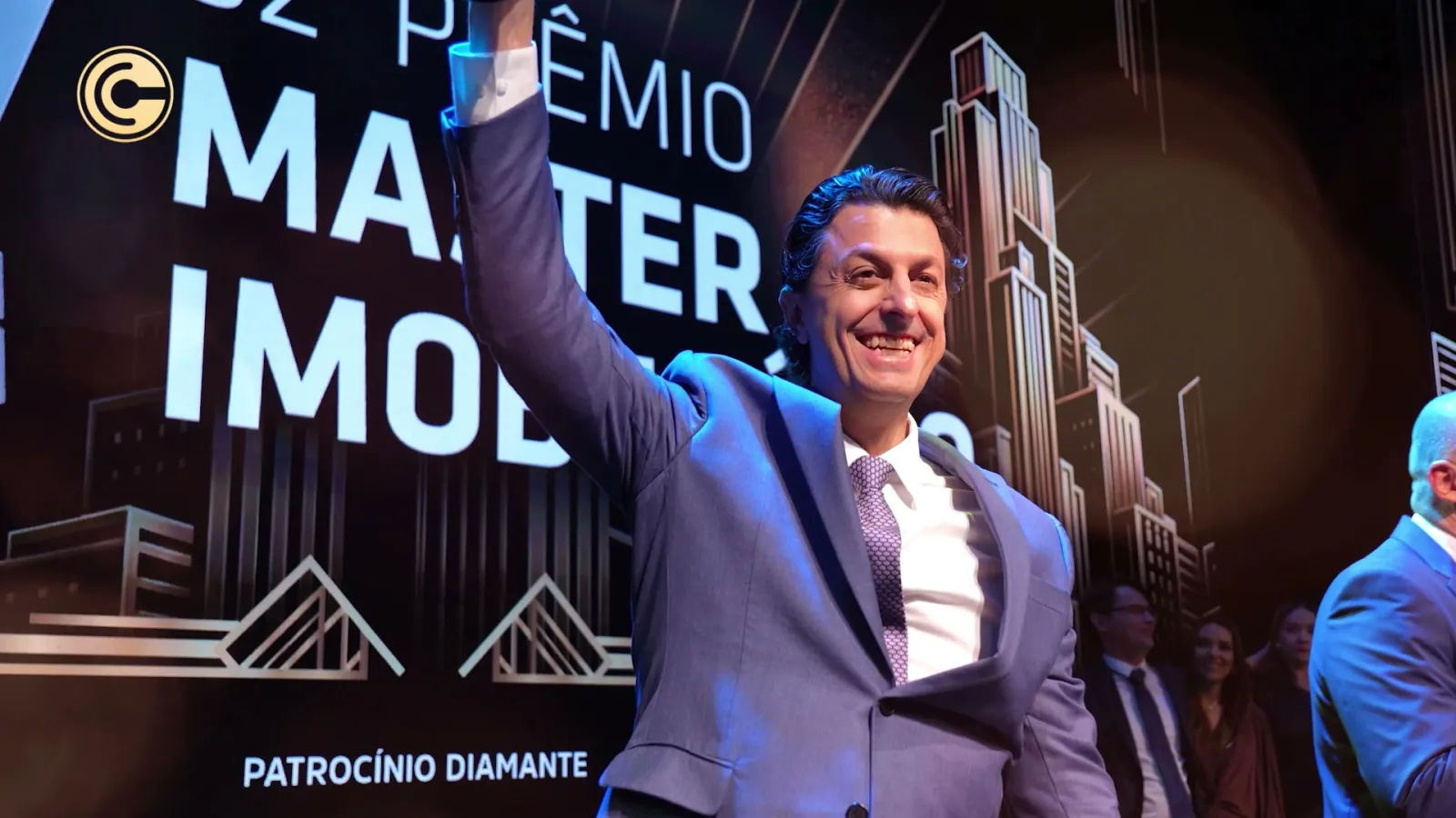 Diretor da Cosentino comemora com o troféu erguido diante do painel do 32º Prêmio Master Imobiliário