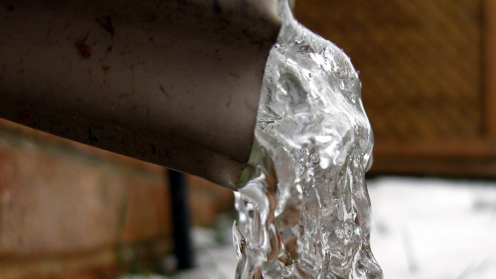 Ice pushing out of the open end of a frozen outdoor pipe