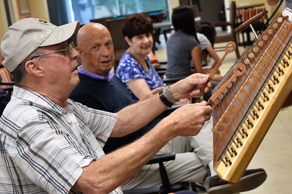 a group of seniors sitting in a line playing an instrument