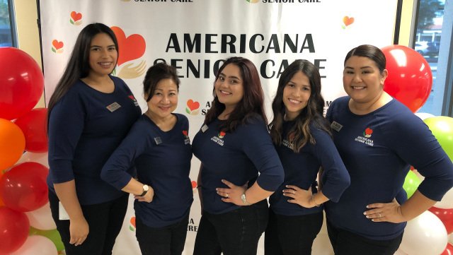 five members of staff standing in a line smiling