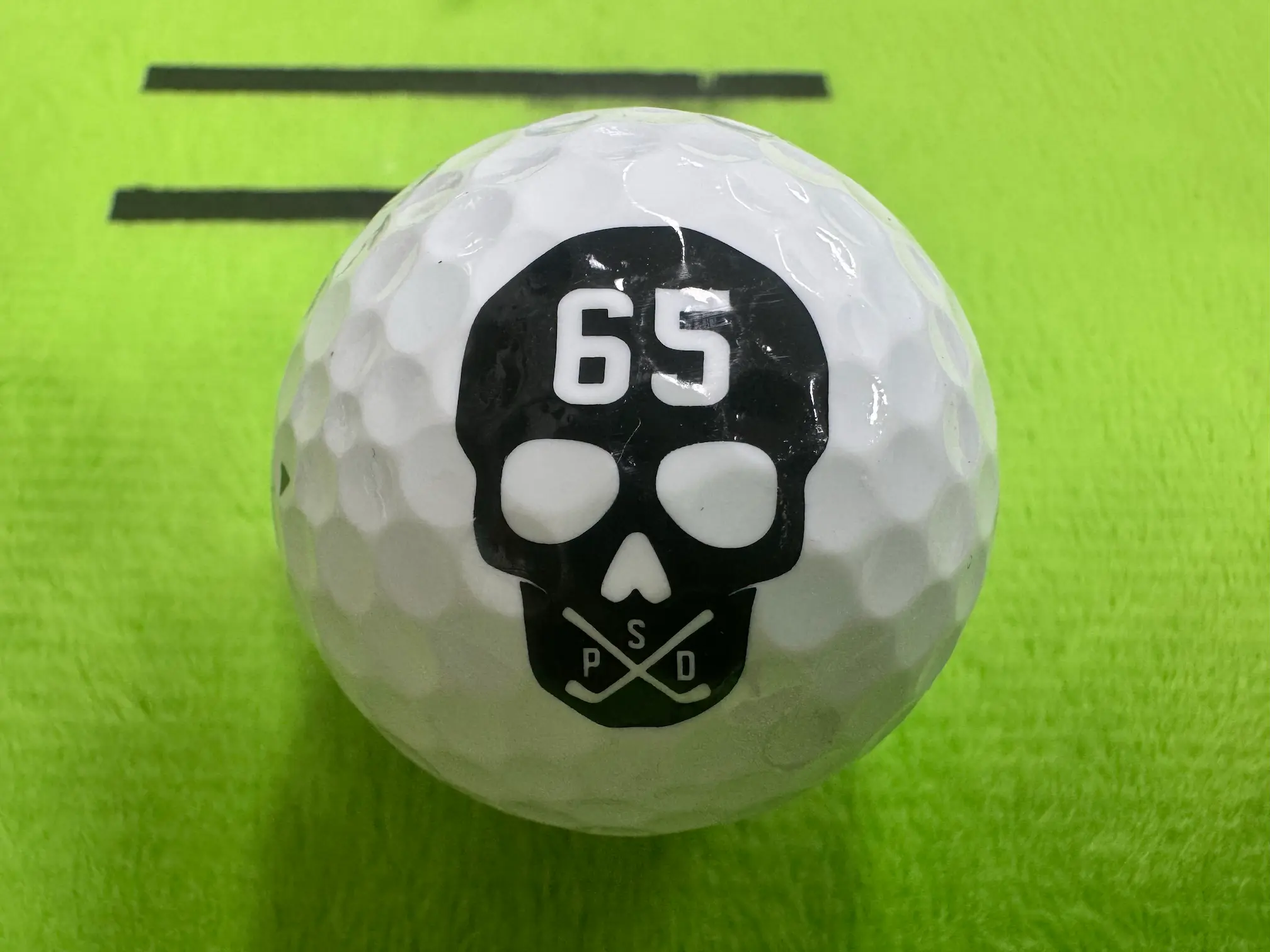 파사디 골프공 뒷면 사진 — 해골 캐릭터와 숫자 65가 보이는 디자인