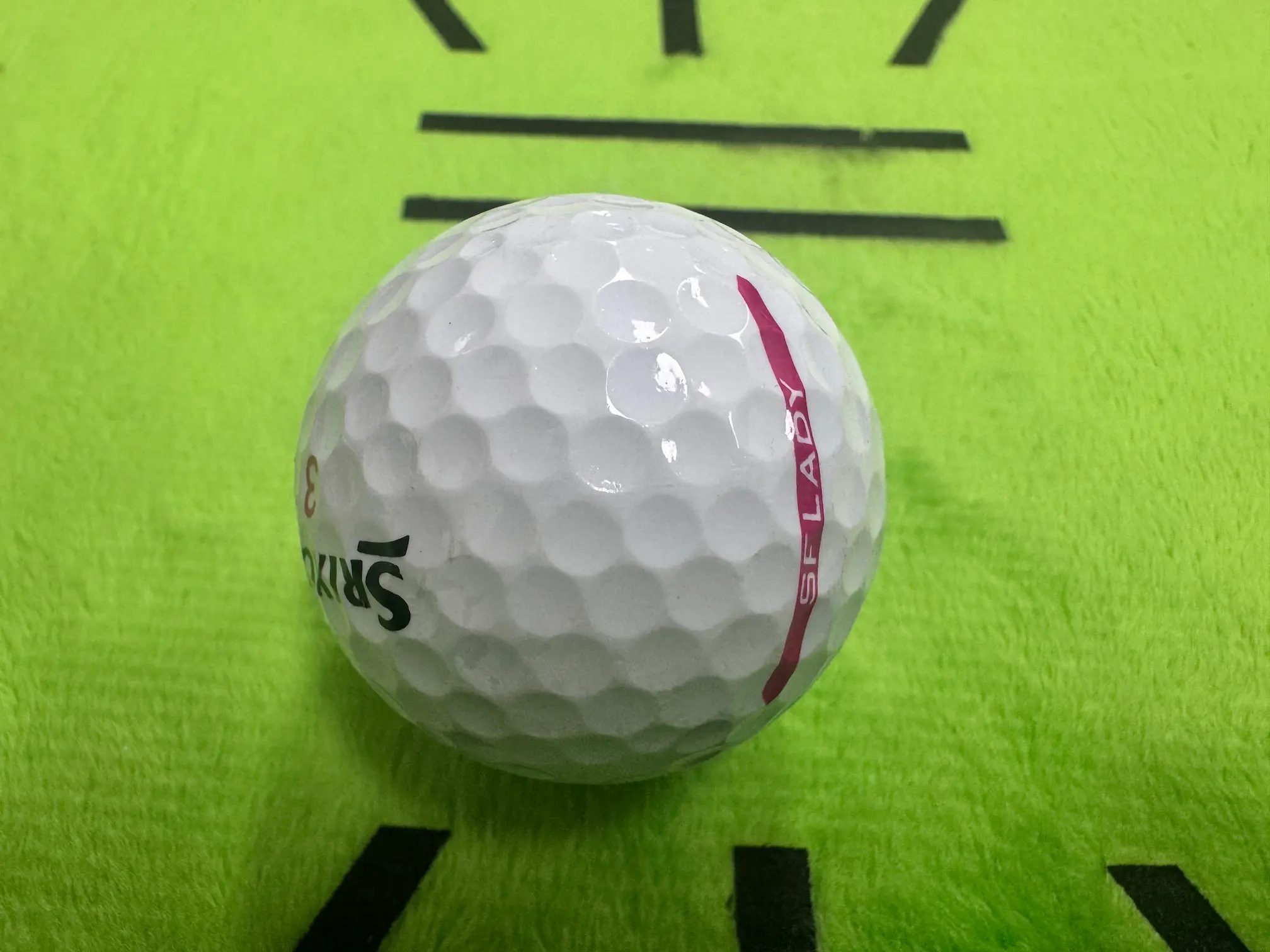스릭슨 SF 레이디 골프공 측면 사진 - 접합부와 SF LADY 문구가 보이는 흰색 골프공