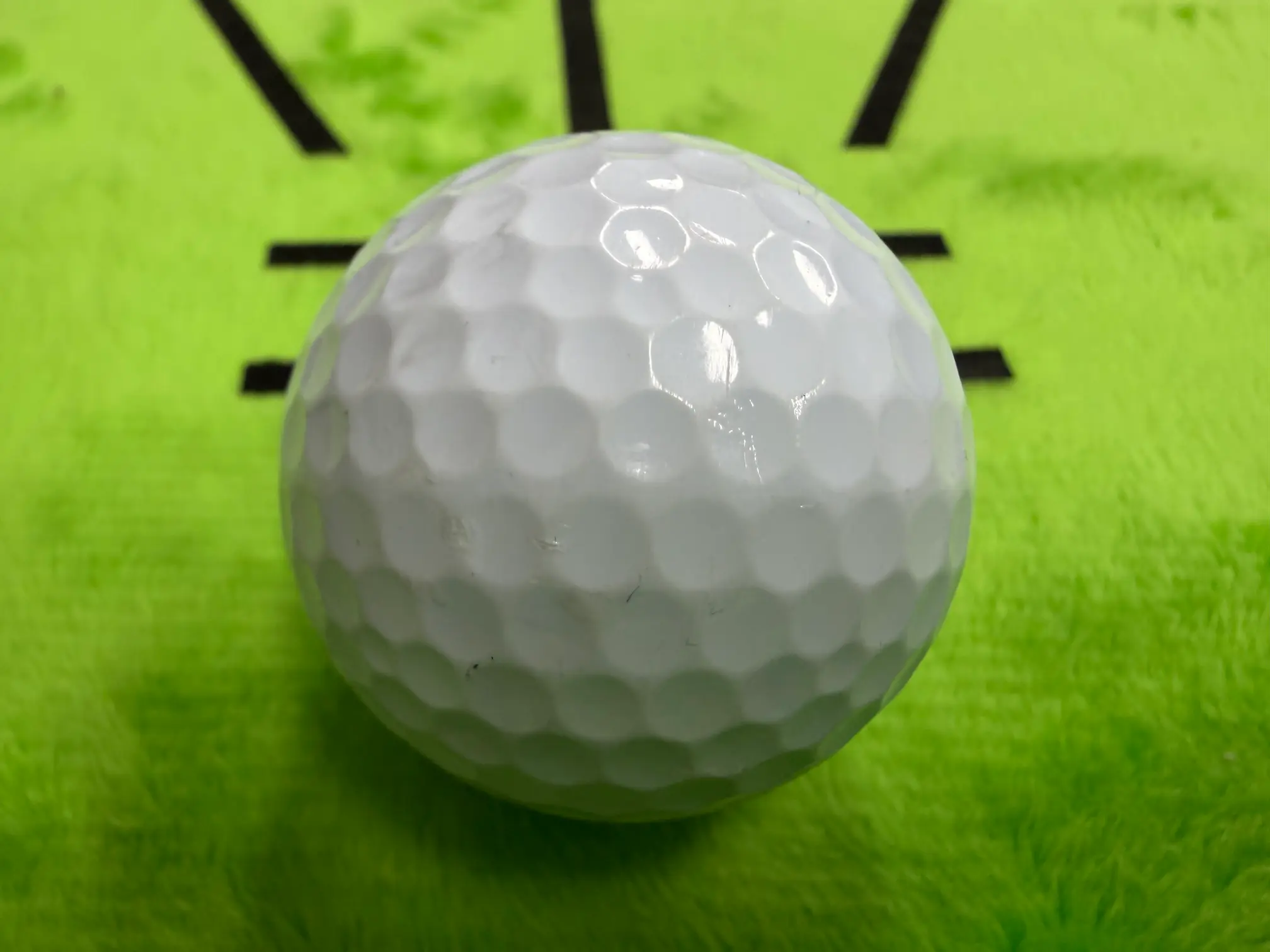 골프공의 깨끗한 흰색 딤플 패턴 클로즈업 사진, 잘 정돈된 무늬가 비행 안정성을 기대하게 만듭니다.