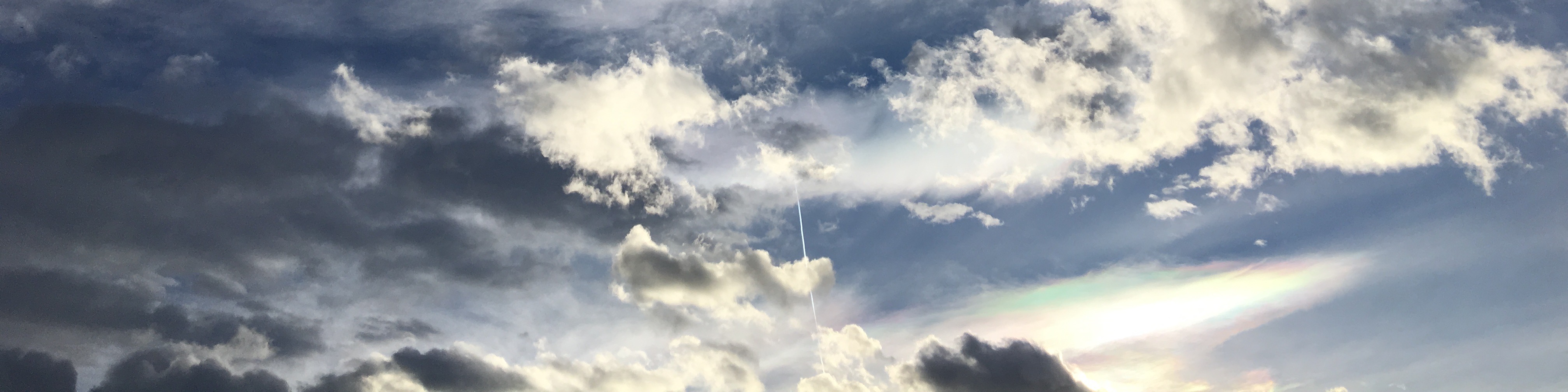 Header image. Sunset with clouds and airplane contrail.