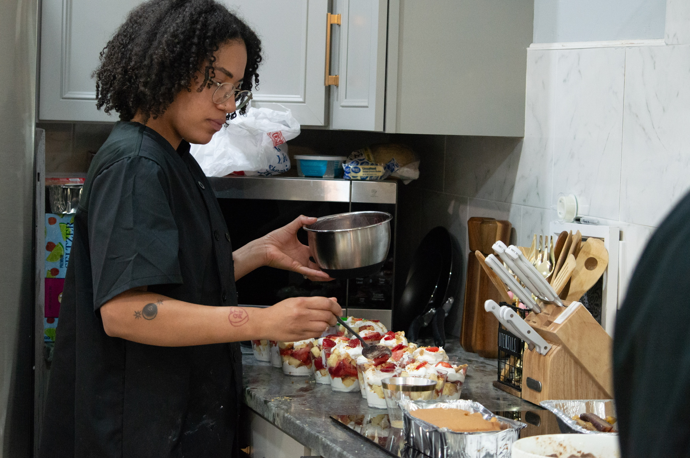 A chef assembling strawberry dessert cups