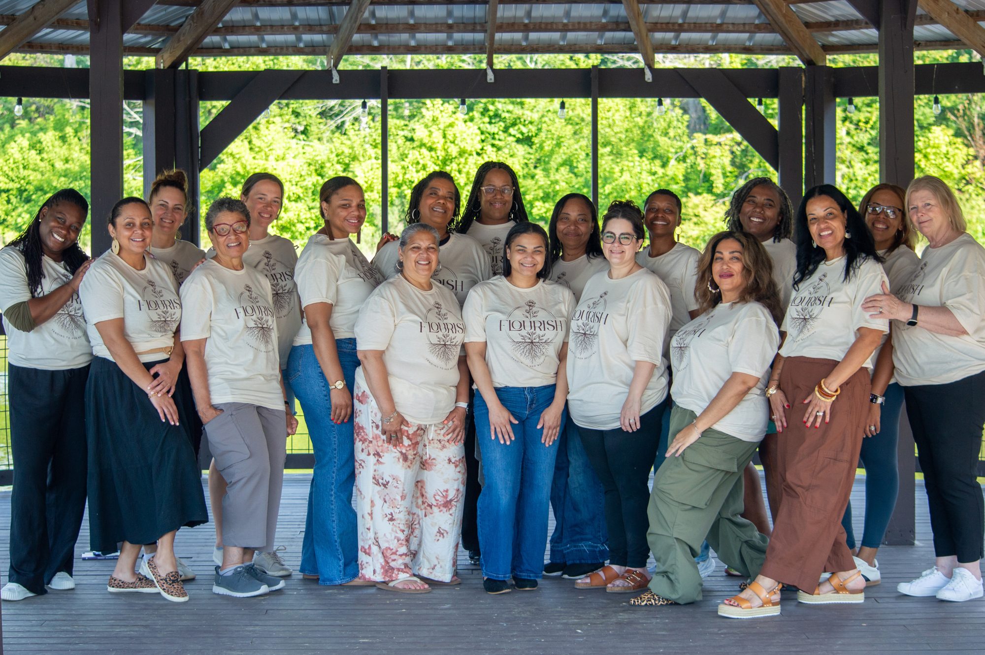 Retreat guests in Flourish shirts gathered in the lakeside pavilion