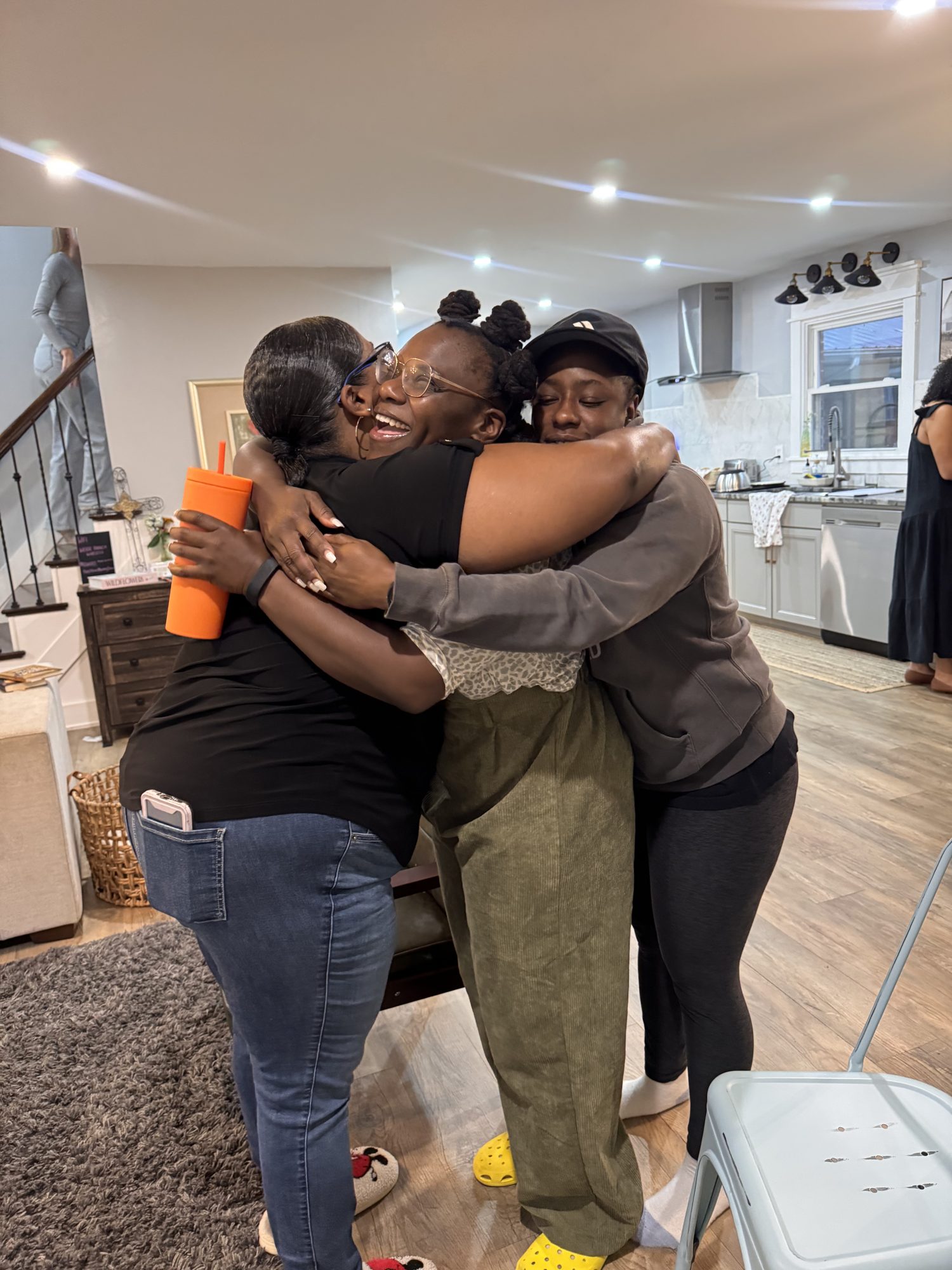 Three women in a joyful group hug