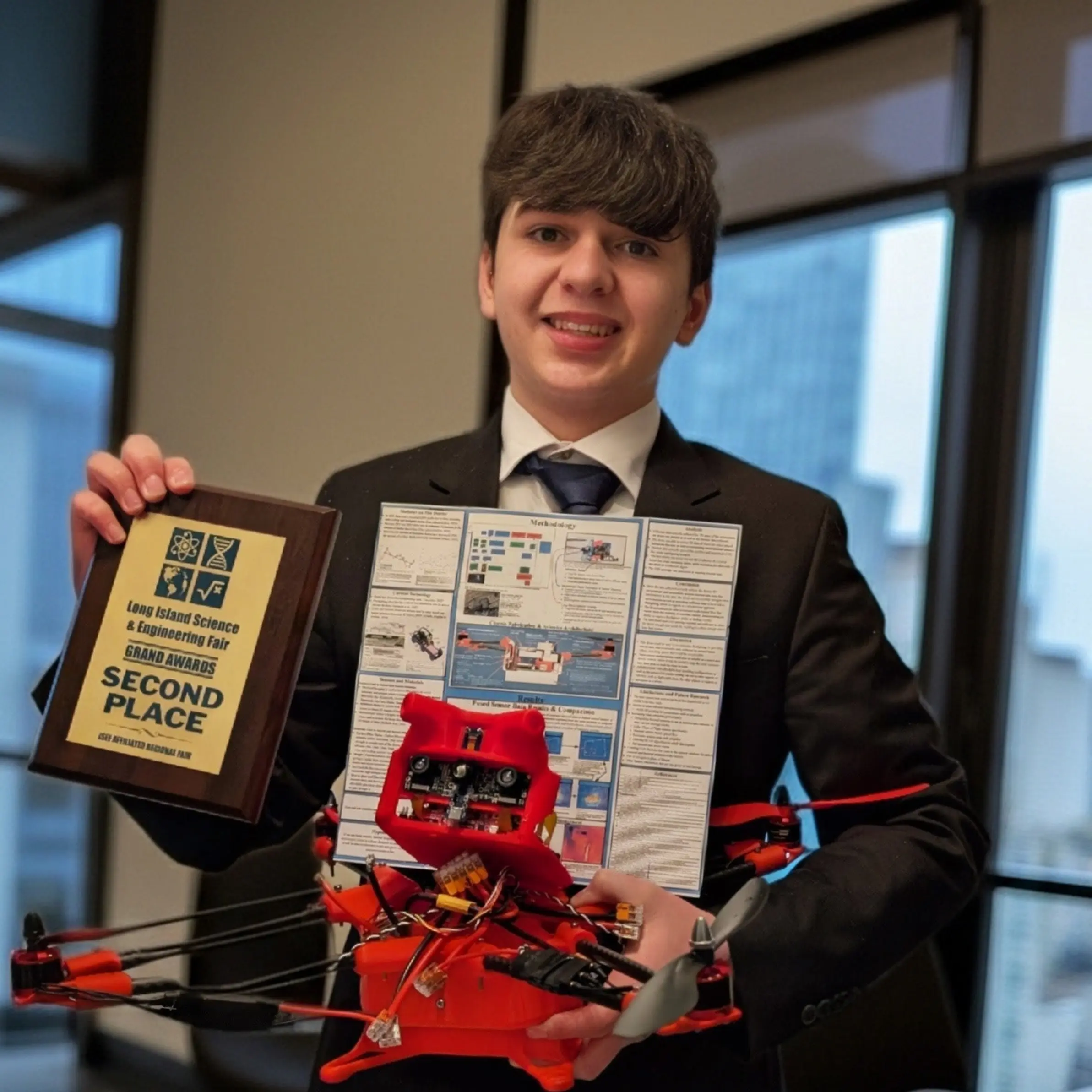 Galileo Solis holding Phoenix Inferno drone and LISEF 2nd Place Grand Award
