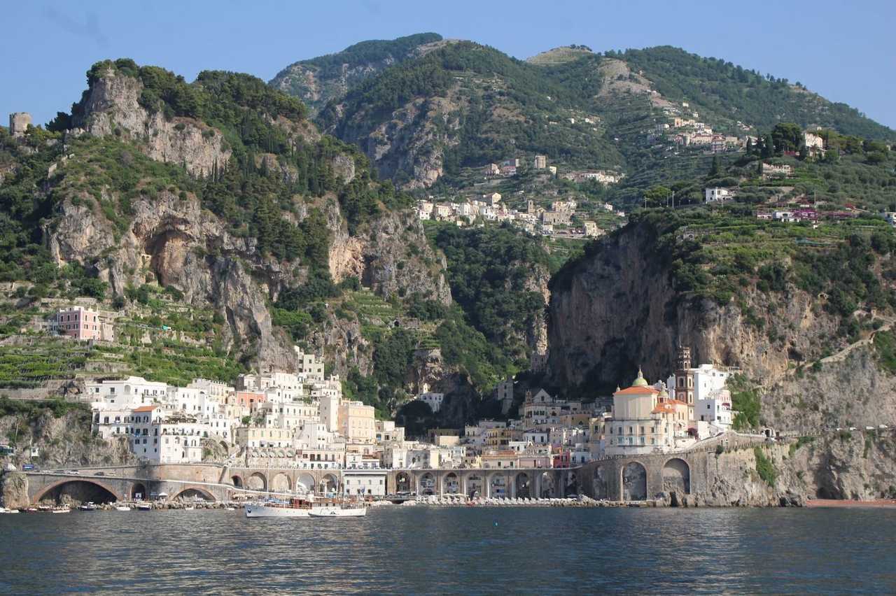Amalfi town under the cliffs from the water, day, blue sky