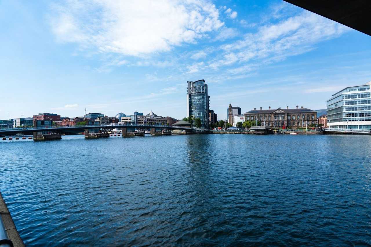 River Lagan weir bridge with The Boat, Custom House and Albert Clock, day, blue sky