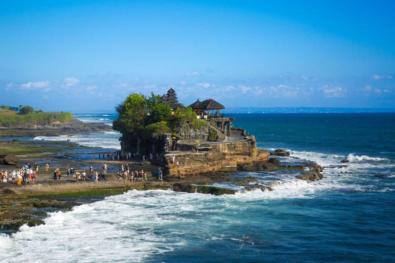 Tanah Lot temple on rock islet, Bali (Benoa port), day, blue sky and surf